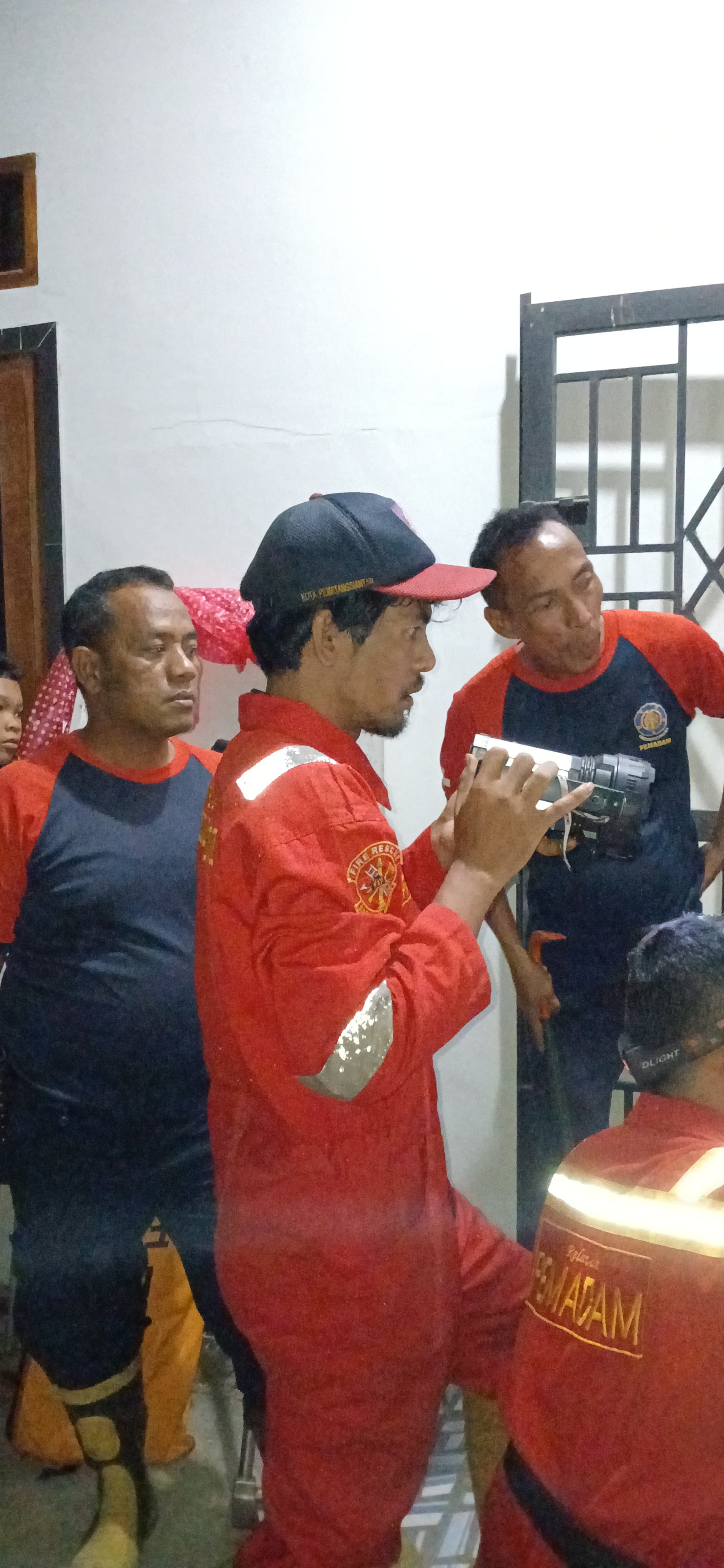 Personil Dinas Pemadam Kebakaran dan Penyelamatan berhasil membuka pintu rumah warga yang terkunci y