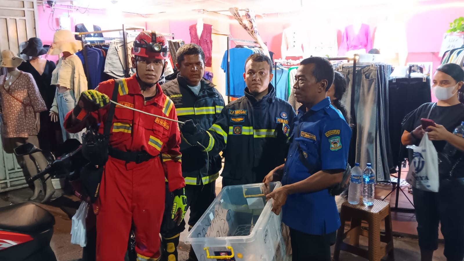 Personil Dinas Pemadam Kebakaran dan Penyelamatan berhasil mengevakuasi seekor ular di Toko Pakaian