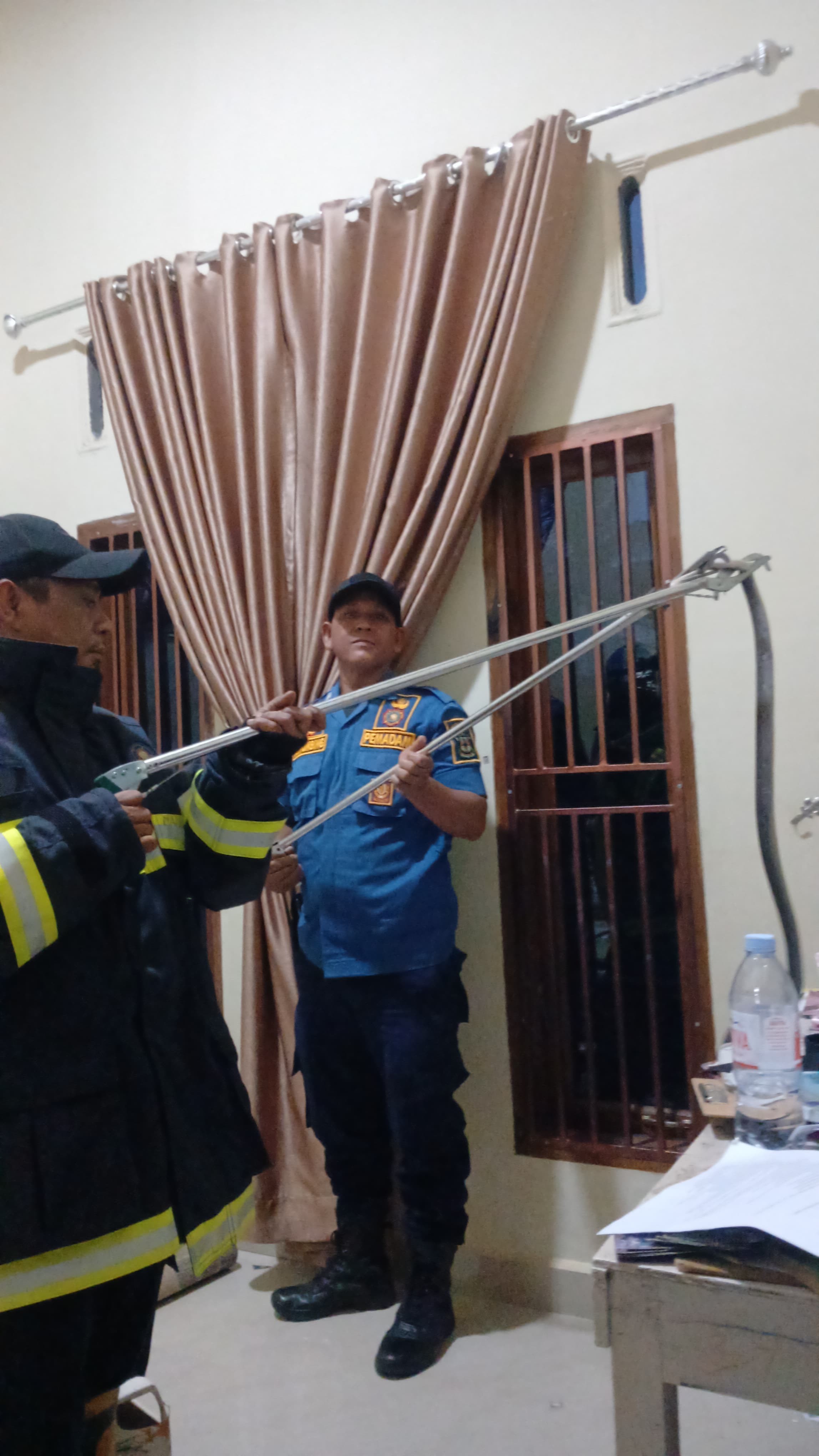 Personil Dinas Pemadam Kebakaran dan Penyelamatan berhasil mengevakuasi ular di rumah warga   Jl. Fa