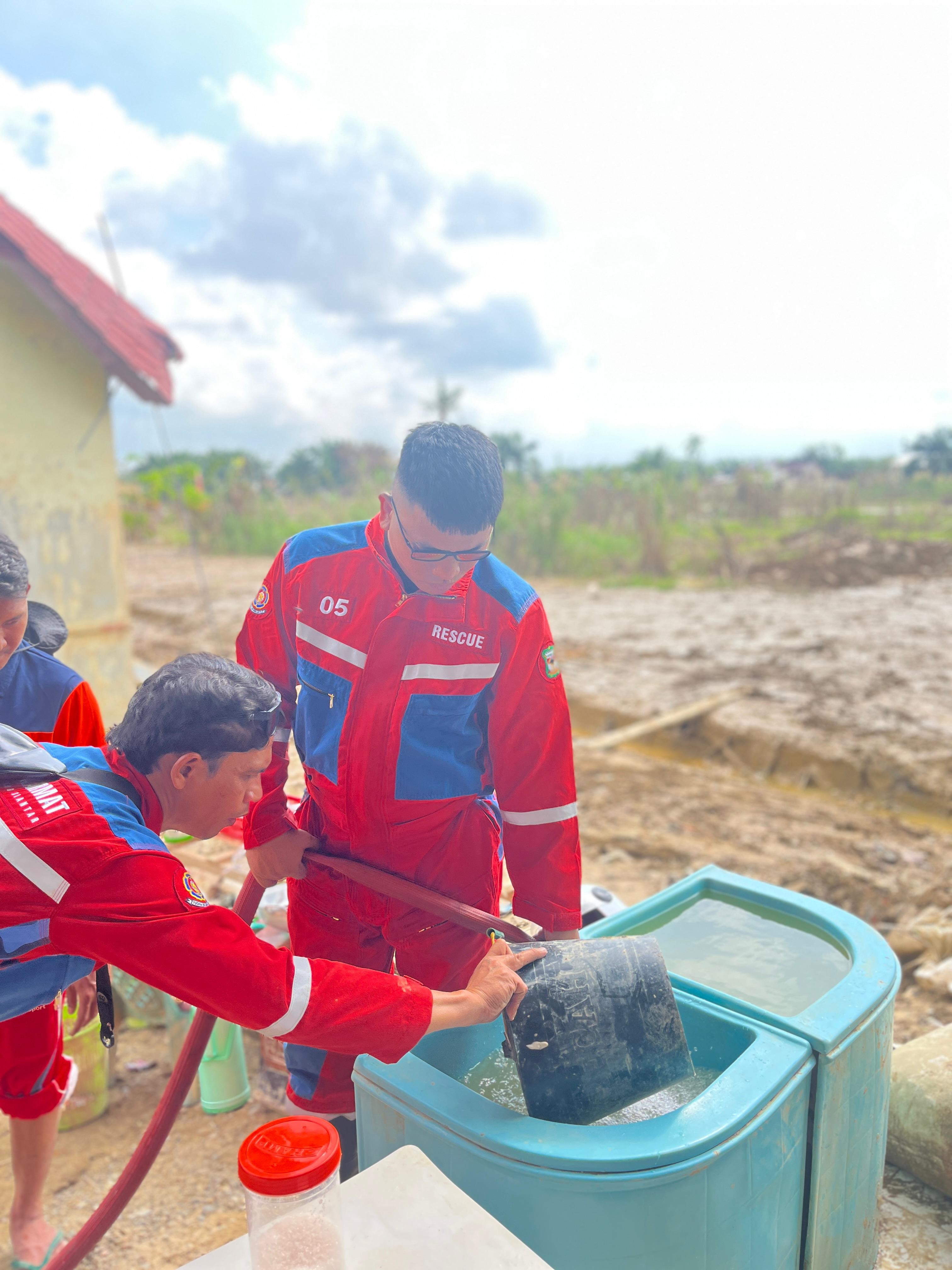 Personil Dinas Pemadam Kebakaran dan Penyelamatan melaksanakan pendistribusian dan membantu pemuliha