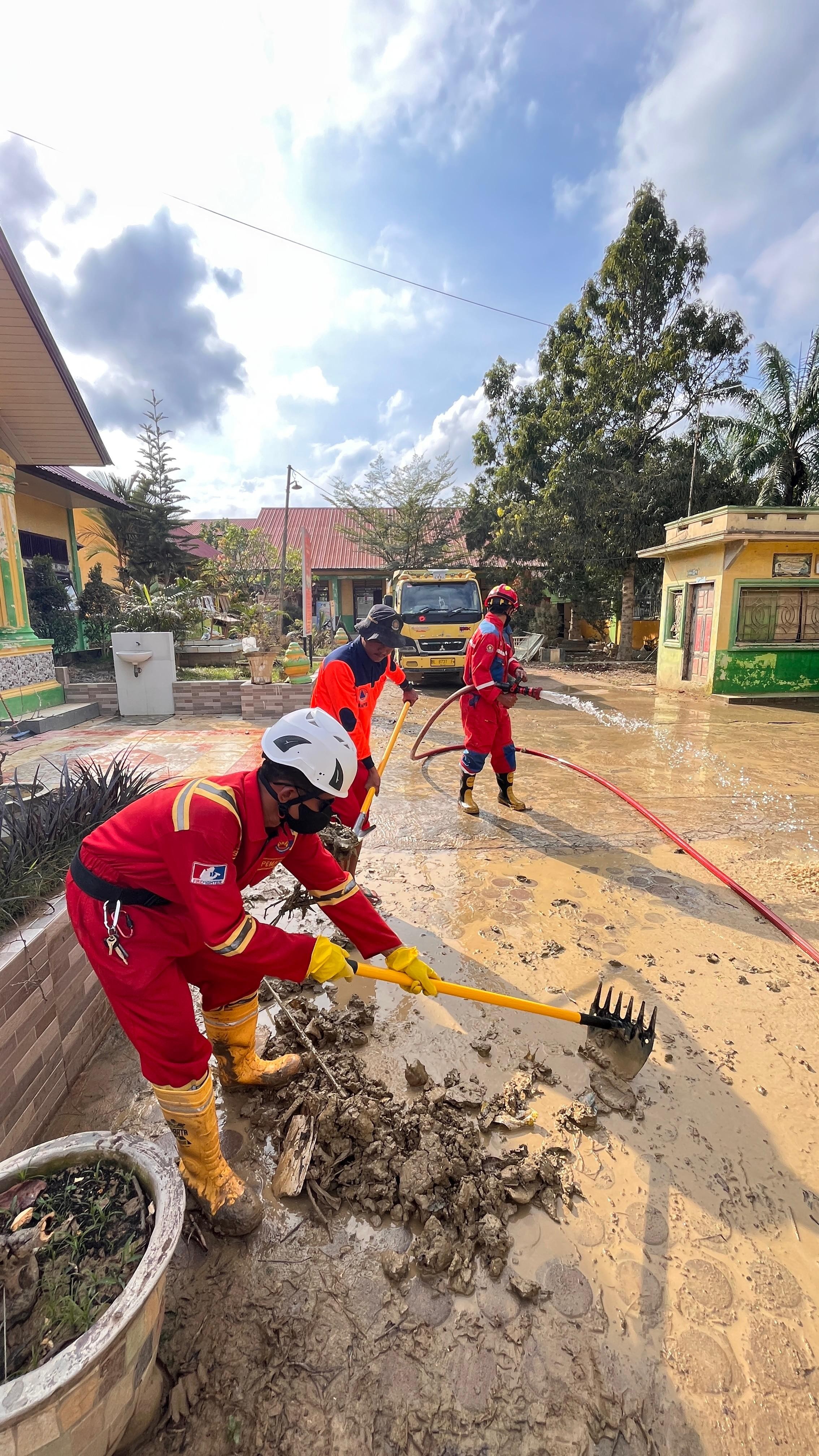 Personil Dinas Pemadam Kebakaran dan Penyelamatan melaksanakan pendistribusian dan membantu pemuliha