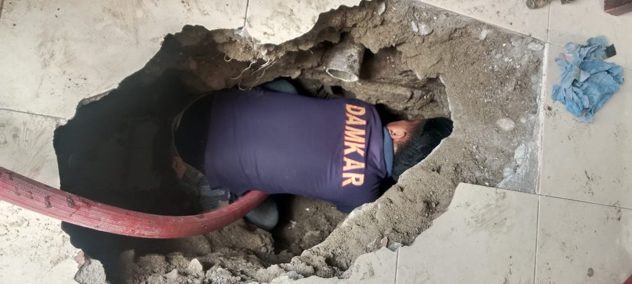 Personil Dinas Pemadam Kebakaran dan Penyelamatan melaksanakan penyemprotan parit yang sumbat di  Jl