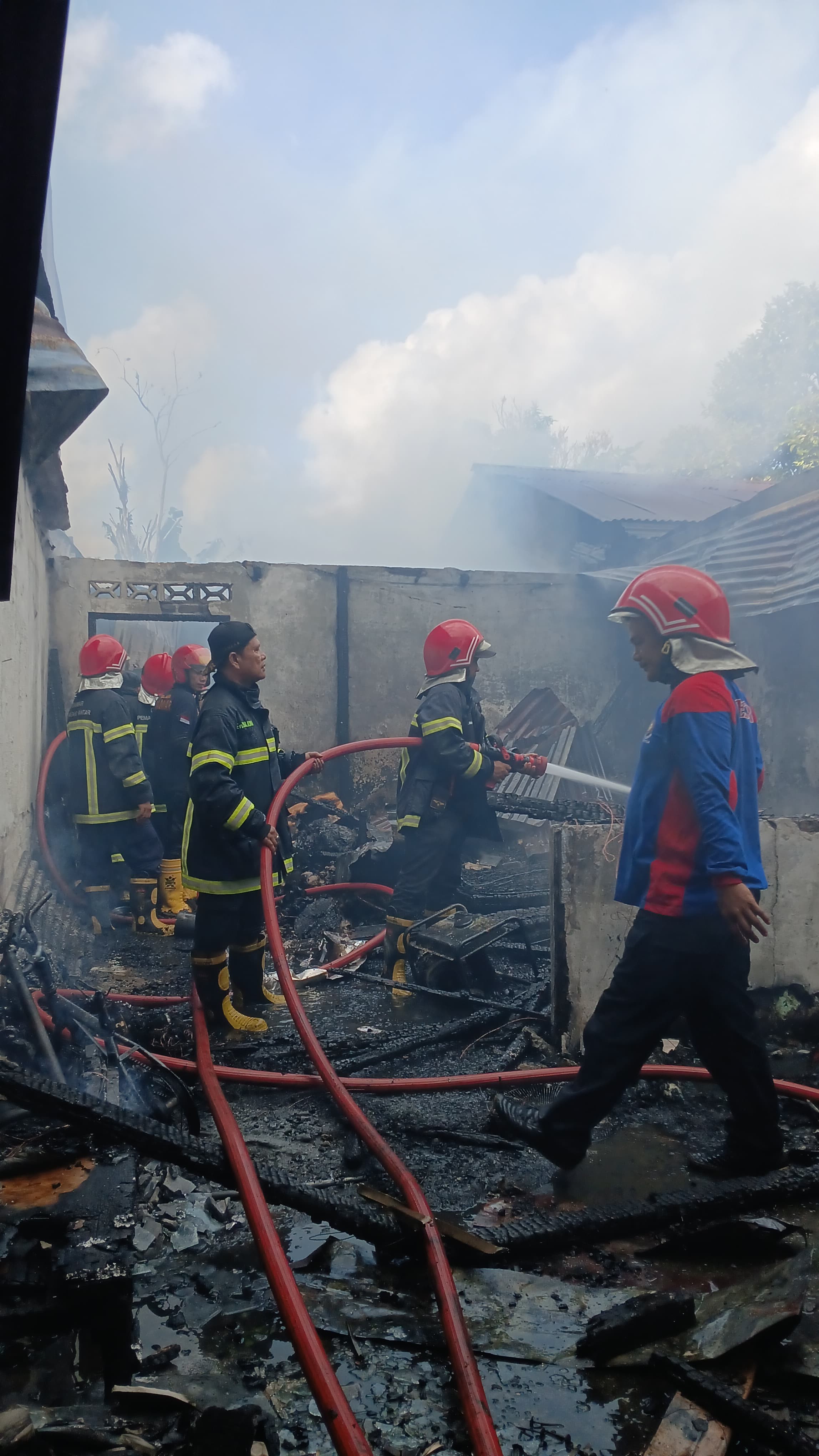 Personil Dinas Pemadam Kebakaran dan Penyelamatan melaksanakan Pemadaman Kebakaran rumah di  Jl. Rak