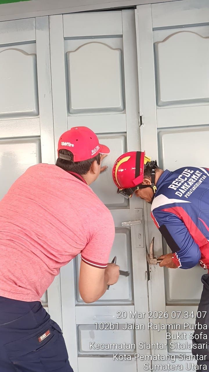 Personil Damkar Siantar berhasil membuka pintu ruko yang terkunci di  Jl. Rajamin Purba