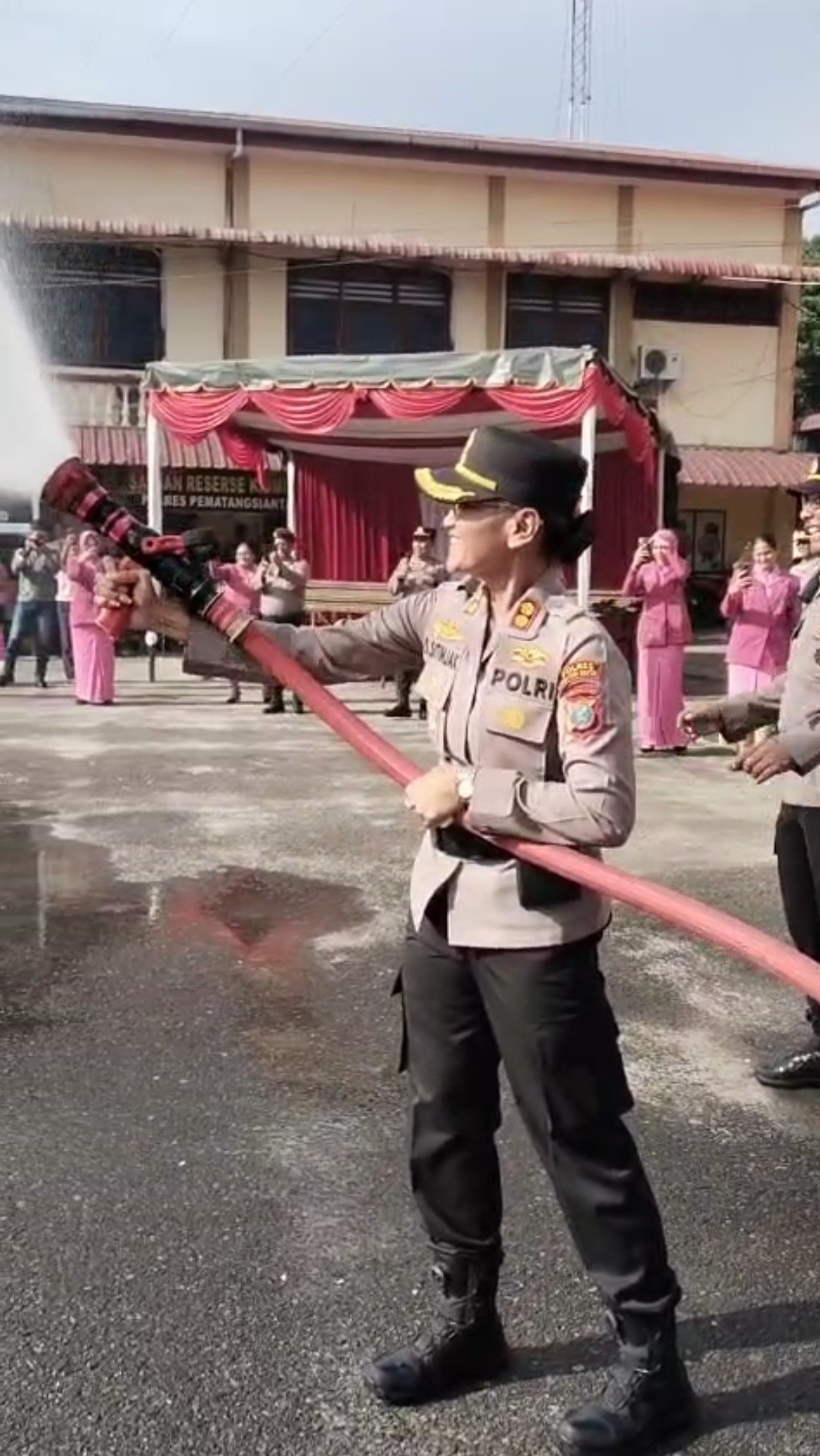 puluhan personel polisi yang baru saja naik pangkat secara simbolis disiram menggunakan air dari mob